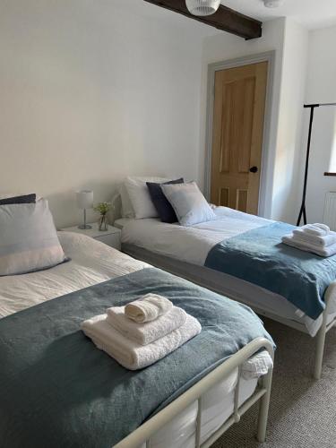 キングズ・リンにあるGrade II Listed 3 Bedroom Cottage With Free Parkingのベッドルームにタオル付きのベッド2台が備わります。
