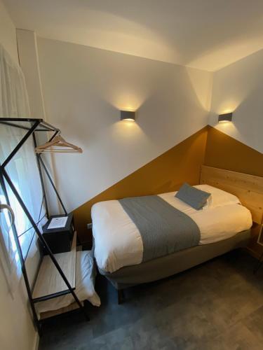 a bedroom with a bed and a window and lights at Lyo Hôtel - Centre Lyon Perrache in Lyon