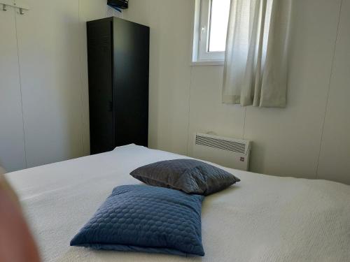 een slaapkamer met een bed met een blauw kussen erop bij Merel in Serooskerke