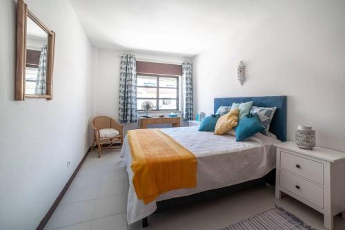 a bedroom with a bed and a desk and a window at Spacious Two bedroom apt, 200m from the beach in Carvoeiro