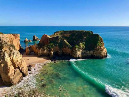 a beach with a large rock formation in the ocean at Spacious Two bedroom apt, 200m from the beach in Carvoeiro