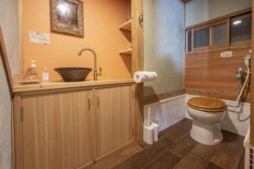Łazienka z drewnianą toaletą i umywalką w obiekcie 古民家一棟貸し宿　山のめぐみ舎 w mieście Niyodogawa