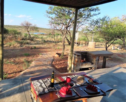 a table with plates and a bottle of wine next to a fireplace at BellaTiny, Tiny House & Gypsy Wagon in Ondekaremba