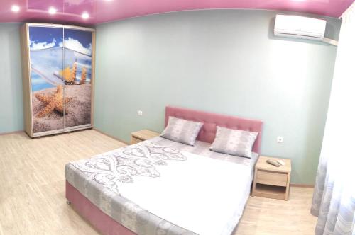 キーウにあるCozy apartments near metro Poznyakiのベッドルーム1室(ベッド1台付)が備わります。壁には絵画が飾られています。