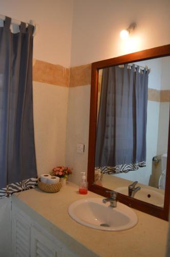 a bathroom with a sink and a mirror at Pole Pole Beach House in Watamu