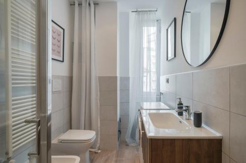 Easylife - Classic and Comfy Porta Romana Flat في ميلانو: حمام مع حوض ومرحاض ومرآة