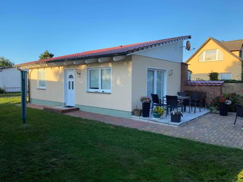 Casa con patio, mesa y sillas en Bungalow "Vera", en Ostseebad Koserow