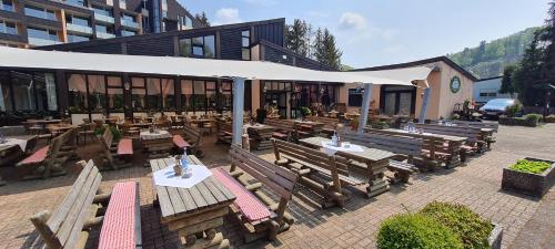 an outdoor restaurant with wooden benches and tables at Hotelpark der Westerwald Treff in Oberlahr