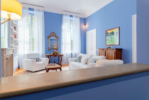 - un salon avec des murs bleus et un mobilier blanc dans l'établissement The Queen, à Turin