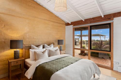 a bedroom with a bed and a large window at STUNNING PANORAMIC OCEAN VIEWS- A Perfect Getaway in Corinella