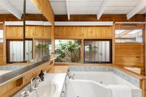 a bathroom with a tub and a sink at STUNNING PANORAMIC OCEAN VIEWS- A Perfect Getaway in Corinella