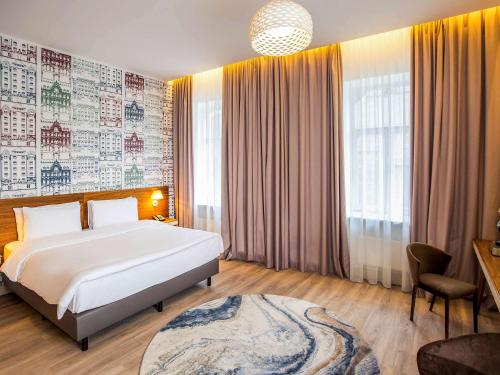 a bedroom with a large white bed and a window at Mercure Riga Centre in Rīga