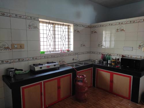 a kitchen with a sink and a counter top at Gruham Malpe Beach Homestay Udupi in Malpe