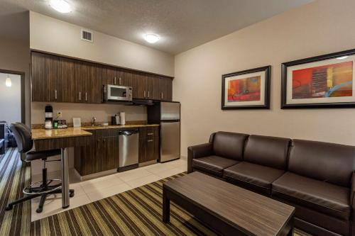 a living room with a couch and a kitchen at Best Western Plus Drayton Valley in Drayton Valley