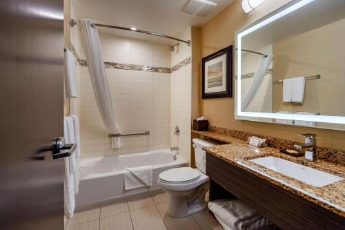 a bathroom with a tub and a sink and a toilet at Best Western Plus Drayton Valley in Drayton Valley