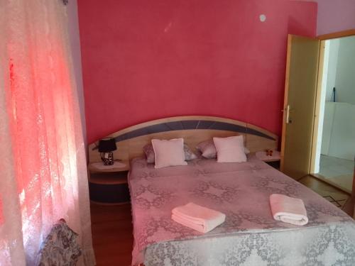1 dormitorio con 1 cama con paredes de color rosa en Biba en Mostar