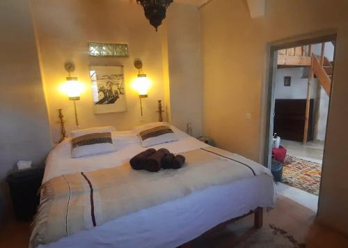 a bedroom with a large bed with two bags on it at Maison d'Hôtes Irocha in Tisselday