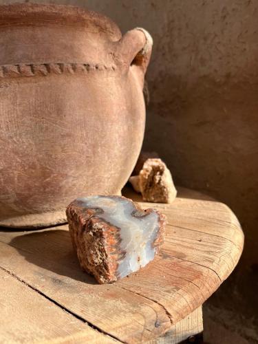 a vase sitting on a wooden cutting board with a rock at Maison d'Hôtes Irocha in Tisselday