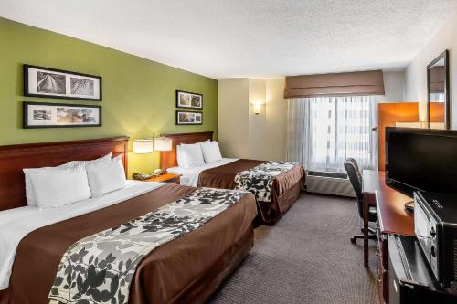 a hotel room with two beds and a flat screen tv at Sleep Inn Gaffney at I-85 in Gaffney