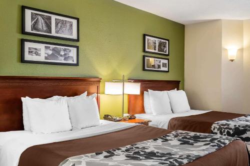 two beds in a hotel room with green walls at Sleep Inn Gaffney at I-85 in Gaffney