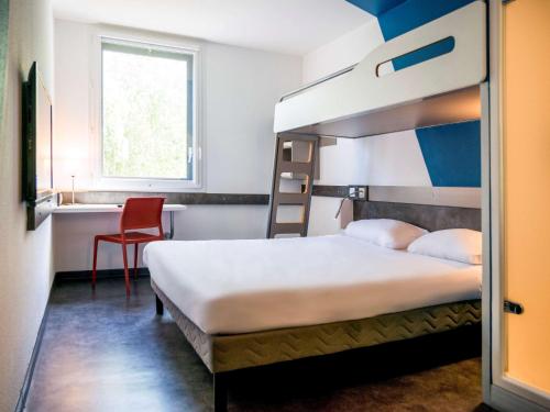 a bedroom with a bunk bed and a desk at Ibis Budget Archamps Porte de Genève in Archamps