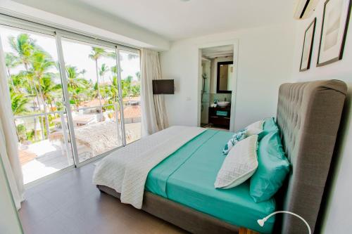 a bedroom with a bed and a view of the ocean at Dream Punta Cana Beachfront Apartment - 4-Bedroom Penthouse with Rooftop BBQ & Ocean Views in Punta Cana