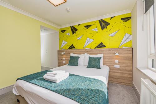 a bedroom with a bed with a yellow wall at Forty Four Main Street in Swords