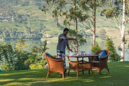 a man standing next to a table in a yard at Ceylon Tea Trails - Relais and Chateaux - All Inclusive in Hatton