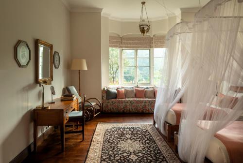 a bedroom with a bed and a couch at Ceylon Tea Trails - Relais and Chateaux - All Inclusive in Hatton