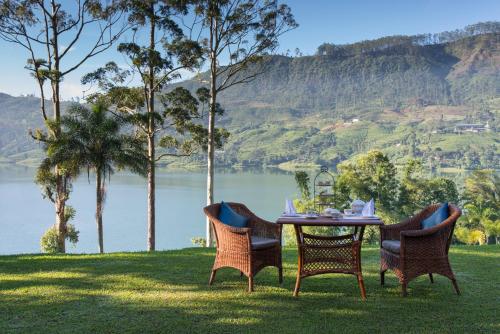 a table and chairs with a view of a lake at Ceylon Tea Trails - Relais and Chateaux - All Inclusive in Hatton