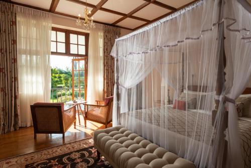 a bedroom with a bed and a couch and a window at Ceylon Tea Trails in Hatton