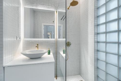a bathroom with a sink and a shower at Hanza Tower 22 WHITE Jacussi & Sauna & Pool & SPA in Szczecin