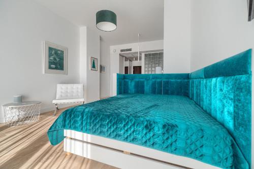 a bedroom with a blue bed with a blue bedspread at Hanza Tower 22 WHITE Jacussi & Sauna & Pool & SPA in Szczecin