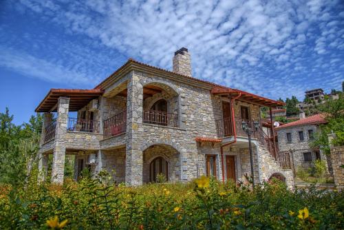 an old stone house with a chimney on top at Omalia Village in Áno Khóra