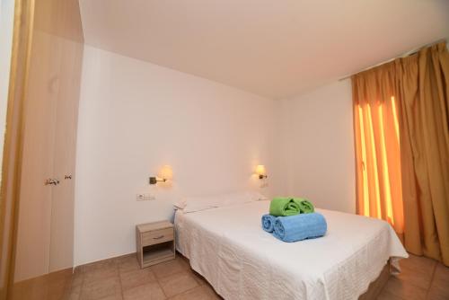 ein Schlafzimmer mit einem Bett mit einem grünen Kissen darauf in der Unterkunft Apartamento rodeado de Natura y Actividades en Canillo HUT-7852 in Canillo