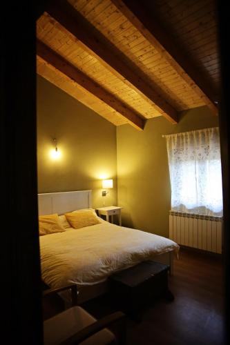 a bedroom with a large bed and a window at Apartamentos turísticos LAS CARBALLEDAS in Rabanal del Camino