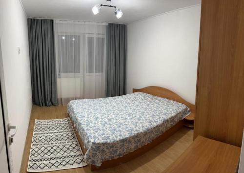 a small bedroom with a bed and a window at Cozy Villa in Piteşti