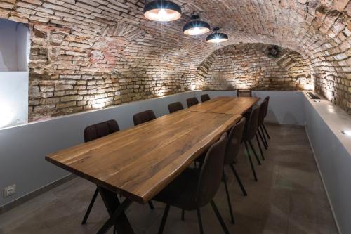 una sala de conferencias con mesa de madera y sillas en Apáca 30 Apartman **** Győr, en Győr