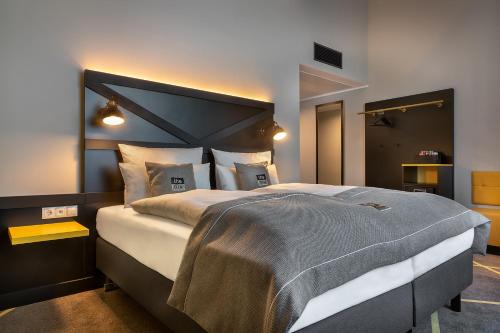 a bedroom with a large bed with a large headboard at the niu Fury in Aschheim