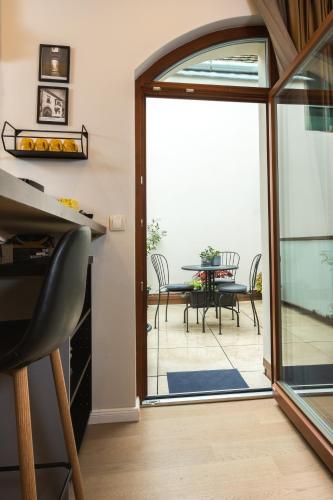 a living room with a sliding glass door with a table at Apáca 30 Apartman **** Győr in Győr