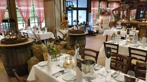 a dining room with white tables and chairs with candles at Hotelpark der Westerwald Treff in Oberlahr