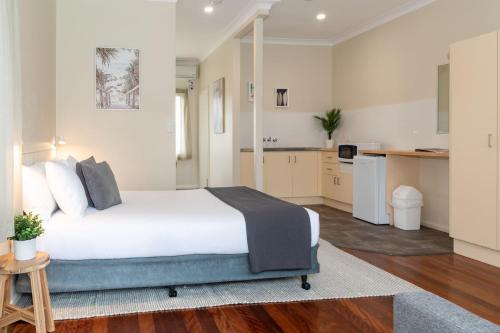 1 dormitorio con 1 cama y cocina en Pacific Motel 06, en Forster