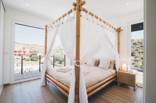 a bedroom with a canopy bed with a window at Antica Villa in Ribamar