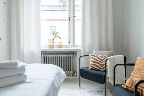a bedroom with a bed and a chair and a window at Luminous studio in Kallio / Amazing location in Helsinki