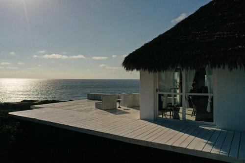 イニャンバネにあるMar-Me-Quer, Eco Beach Retreatの海の景色を望むデッキ付きの家