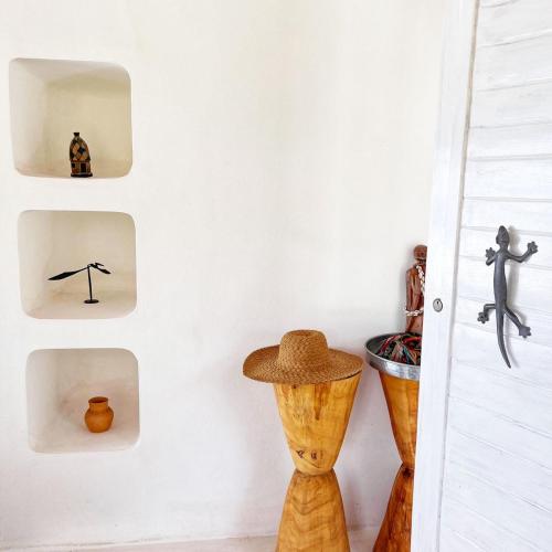 a room with vases and a hat on a wall at Mar-Me-Quer, Eco Beach Retreat in Inhambane