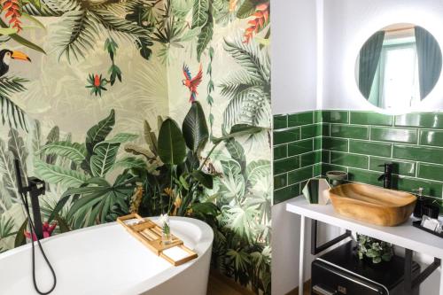a bathroom with green tiles and a tub and a sink at Dunakavics XIII Apartman in Szentendre