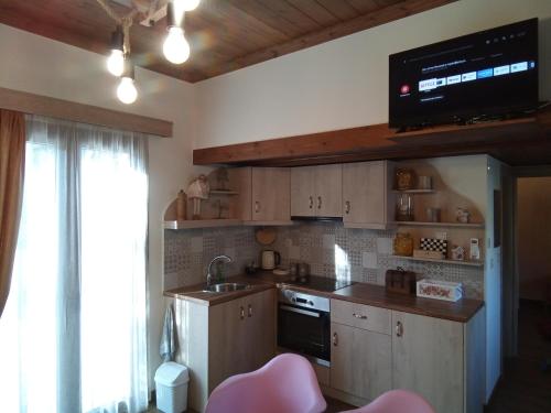 a kitchen with a sink and a tv on the wall at Villa Gianna in Karpenisi