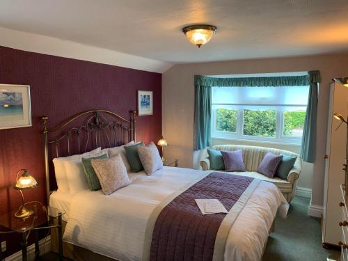 a bedroom with a large bed and a window at Glendower House in Minehead