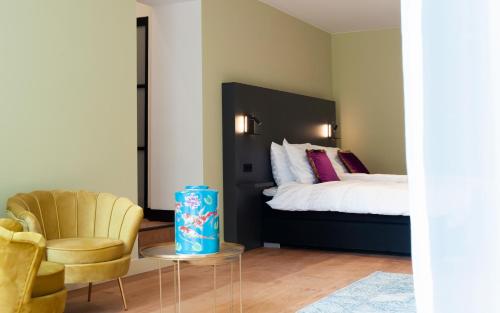 a bedroom with a bed and a chair at Boutique Hotel De Salon in The Hague